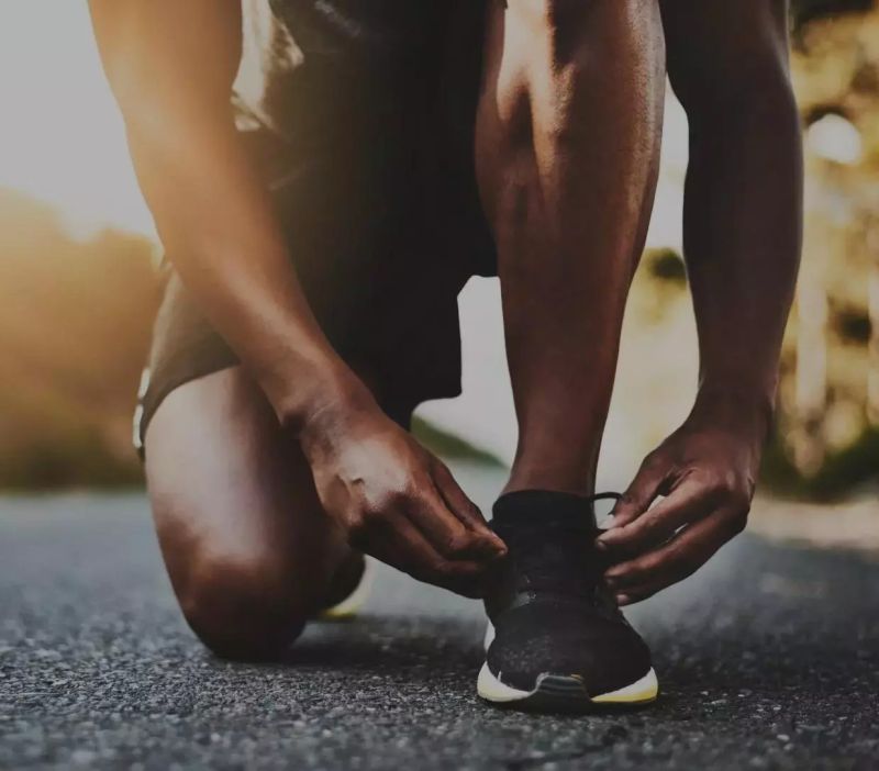 close up of male tying his shoelace ready for a run